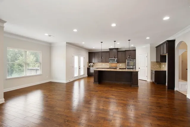 a kitchen with stainless steel appliances granite countertop a sink a stove and a wooden floors