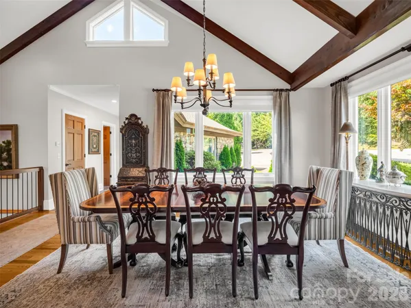 a kitchen with stainless steel appliances granite countertop a table chairs and a refrigerator