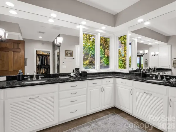 a bathroom with a granite countertop sink toilet and mirror