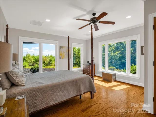 a spacious bedroom with a bed and wooden floor