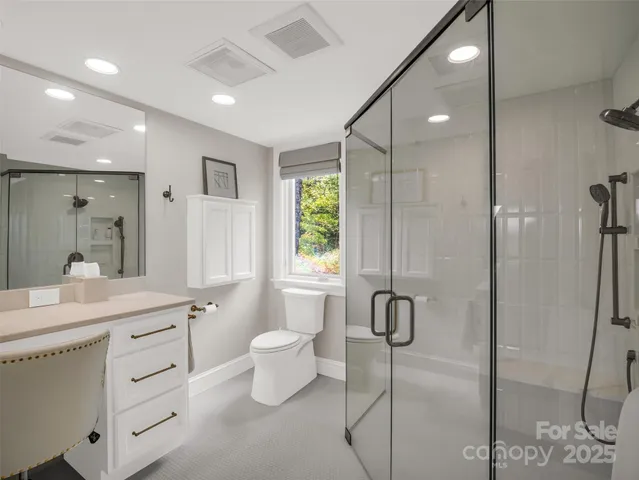 a spacious bathroom with a granite countertop sink mirror and a shower
