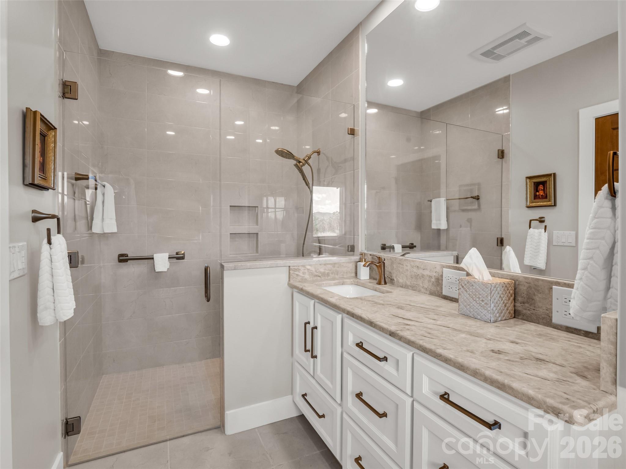 2435 Deep Gap Farm Road East Mill Spring, NC 28756 - Photo 37 of 42 a spacious bathroom with a granite countertop sink mirror and shower