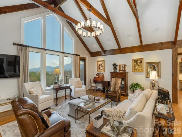 a dining room with furniture a chandelier and wooden floor