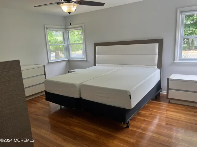 a large bed sitting in a bedroom next to a window and a chandelier