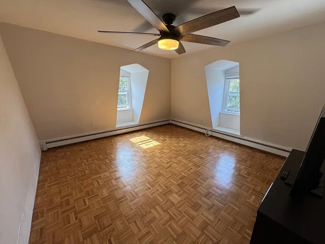 en empty room with window and a ceiling fan