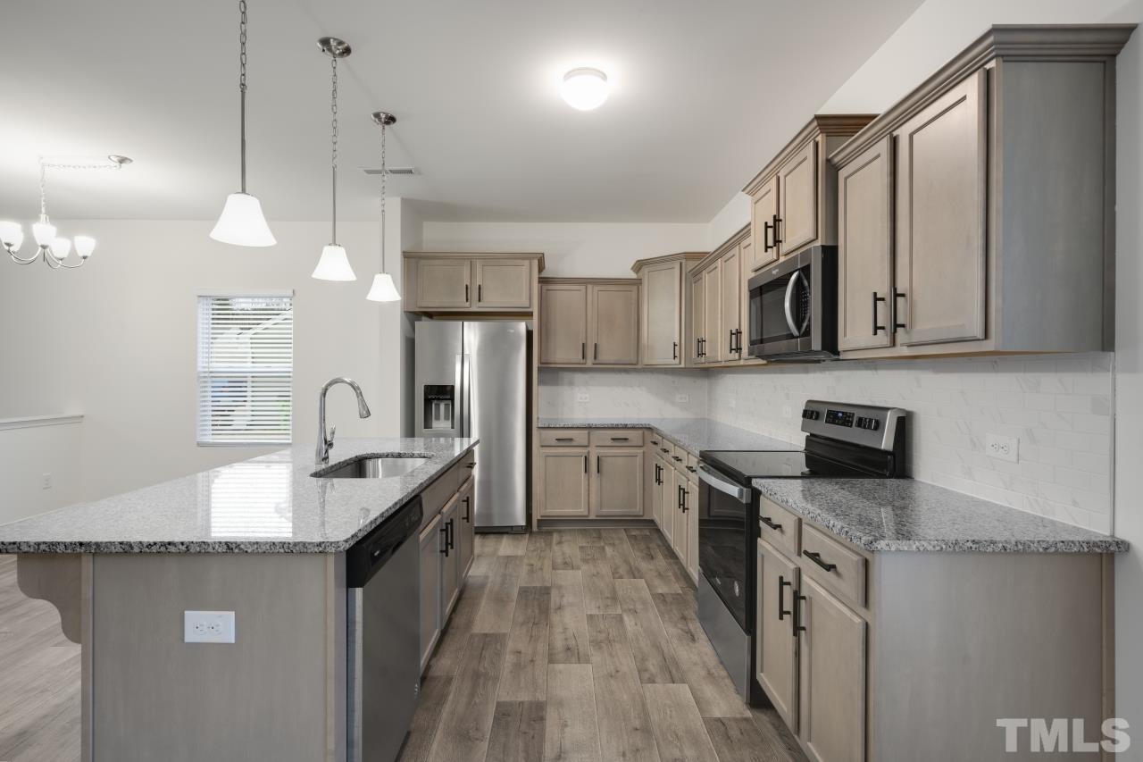 309 Connect Drive Wendell, NC 27591 - Photo 11 of 29 a kitchen with stainless steel appliances granite countertop a sink stove and refrigerator