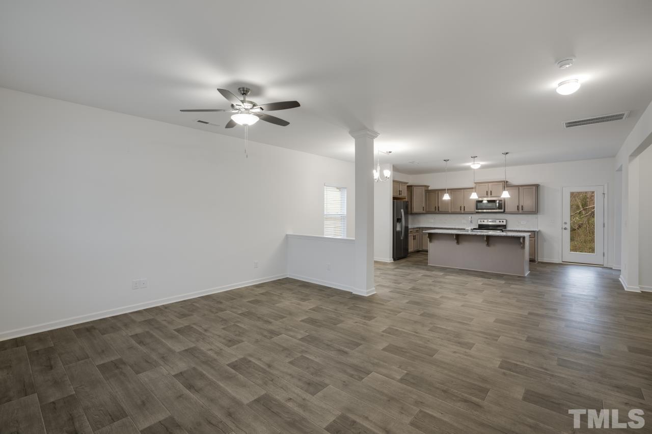 309 Connect Drive Wendell, NC 27591 - Photo 5 of 29 a view of kitchen with a sink a kitchen island white cabinets and stainless steel appliances