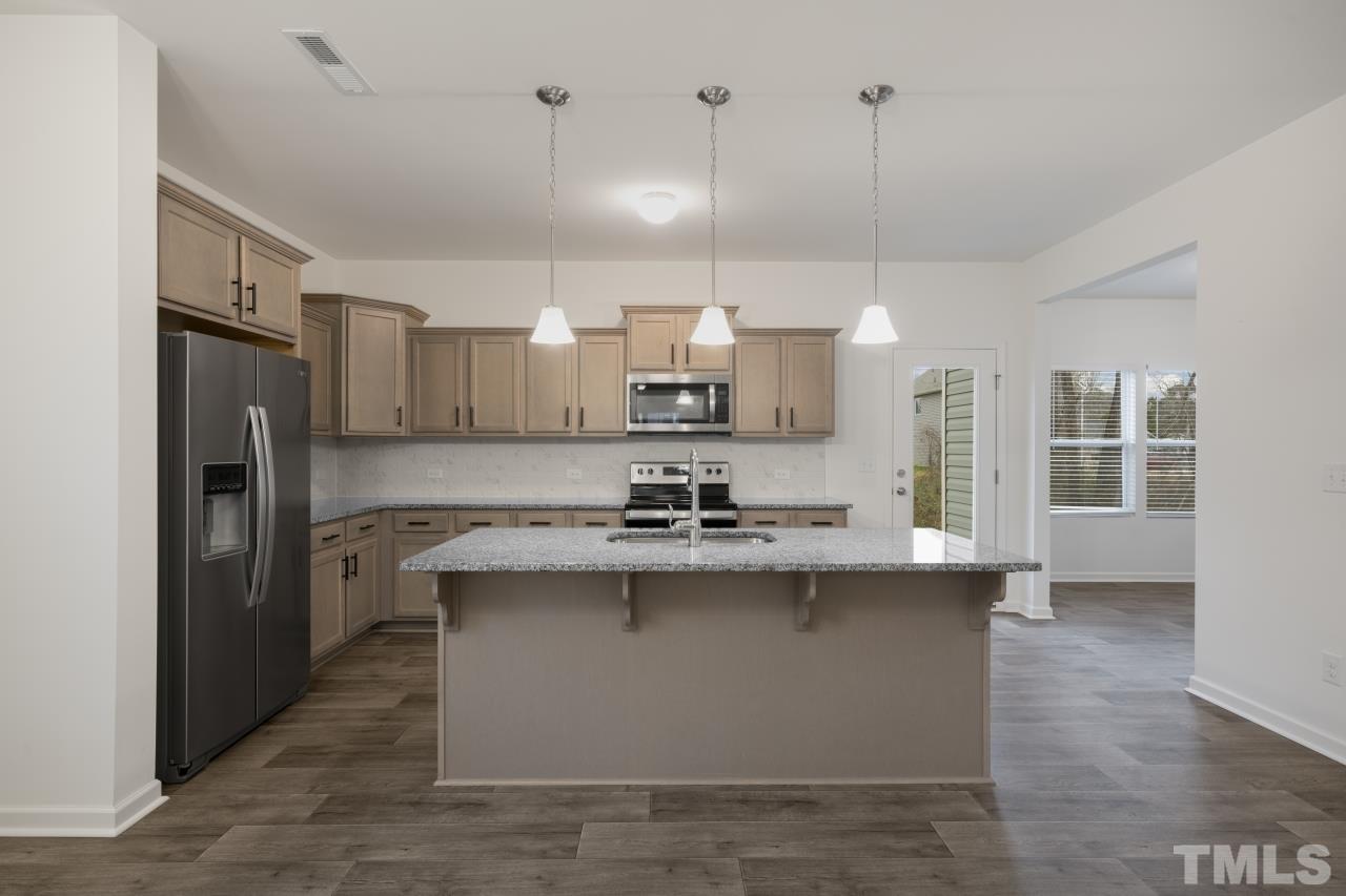 309 Connect Drive Wendell, NC 27591 - Photo 9 of 29 a kitchen with kitchen island a sink stainless steel appliances and cabinets