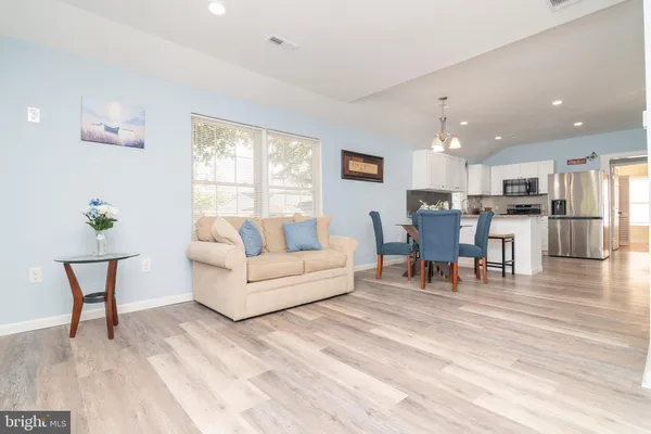 a living room with furniture and a dining table with kitchen view