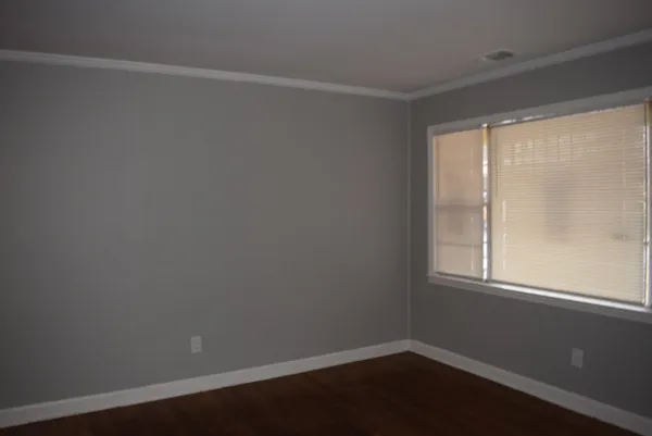 a view of a small space with wooden floor and a window