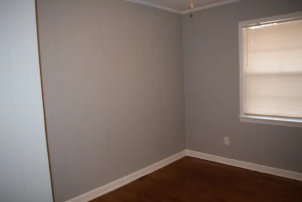a view of a small space with wooden floor and a window
