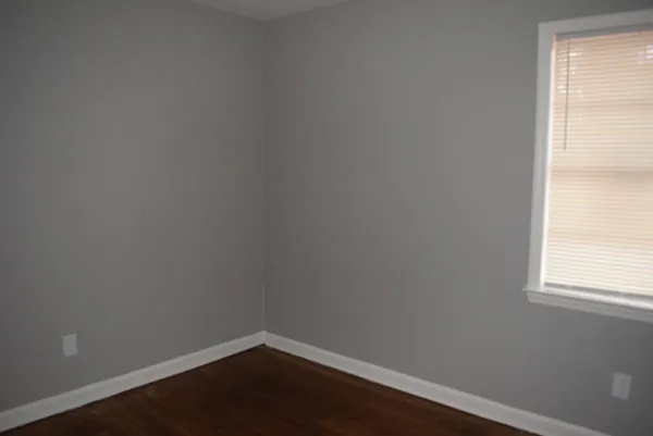 a view of a small space with wooden floor and a window