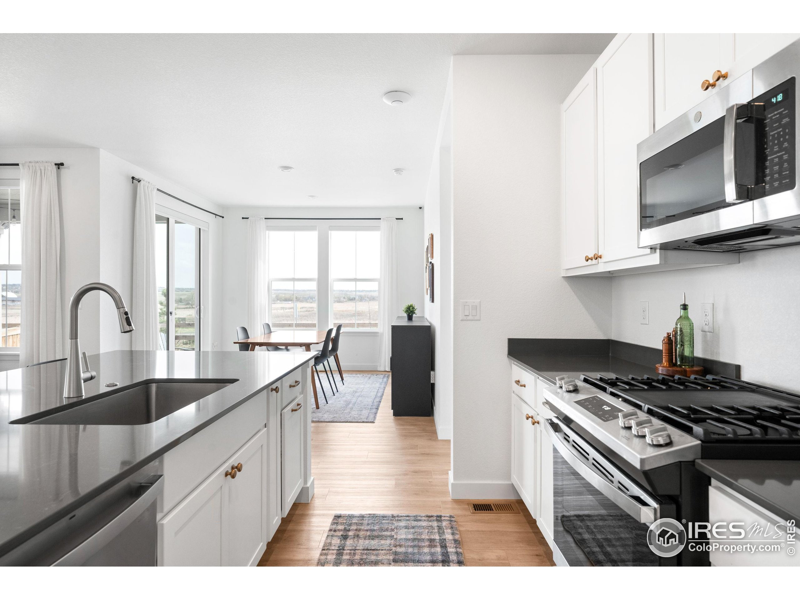 840 Clover Loop Lafayette, CO 80026 - Photo 12 of 39 a kitchen with stainless steel appliances granite countertop a stove a sink and a microwave