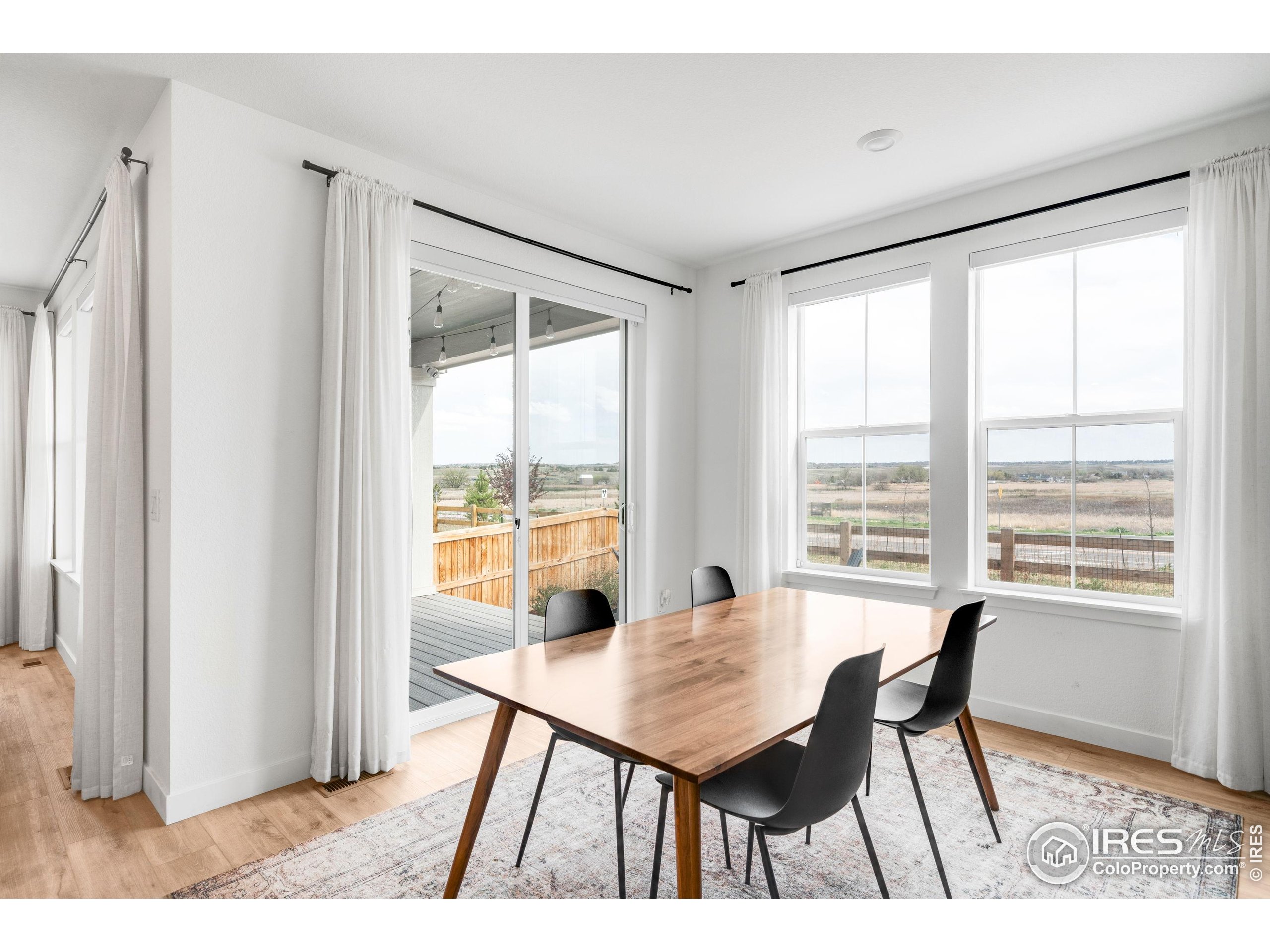 840 Clover Loop Lafayette, CO 80026 - Photo 15 of 39 a view of a dining room with furniture and wooden floor