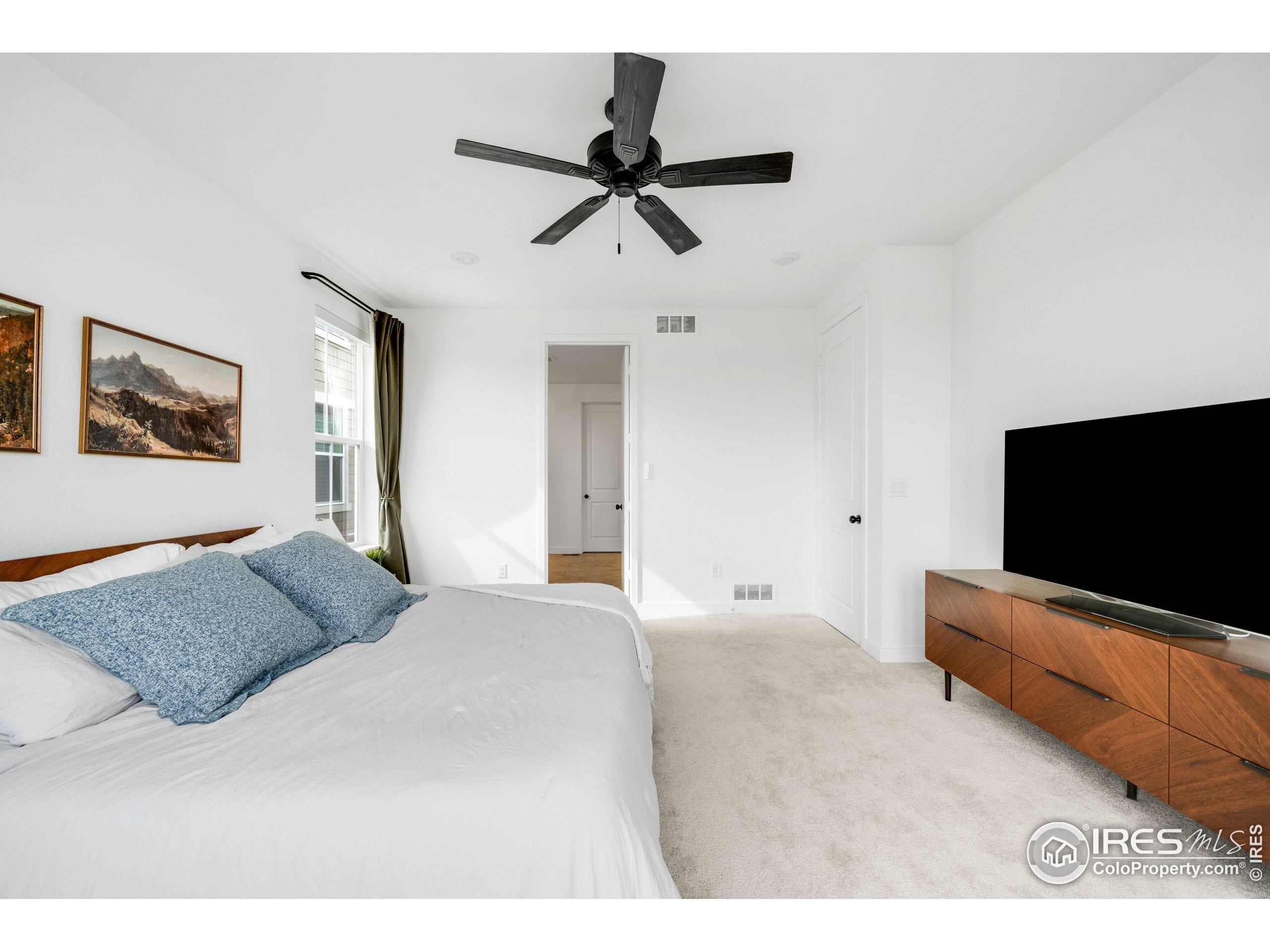 840 Clover Loop Lafayette, CO 80026 - Photo 19 of 39 a bedroom with a bed and a flat screen tv