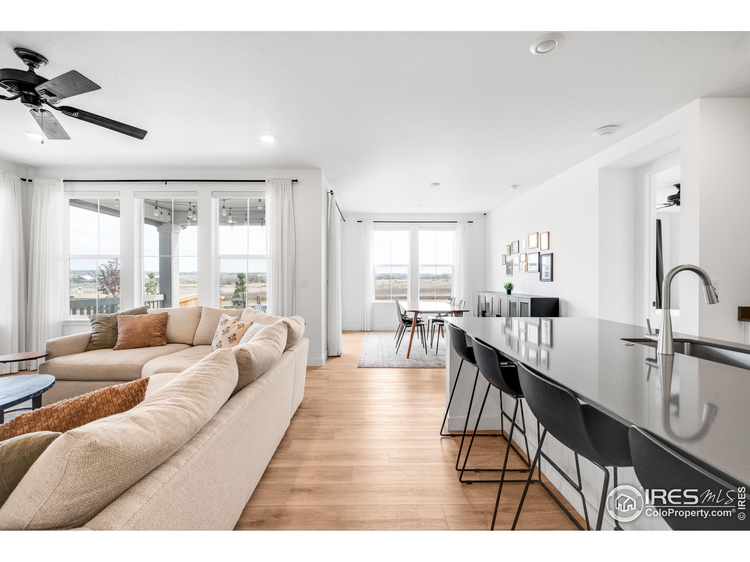 840 Clover Loop Lafayette, CO 80026 - Photo 5 of 39 a living room with furniture a large window and wooden floor