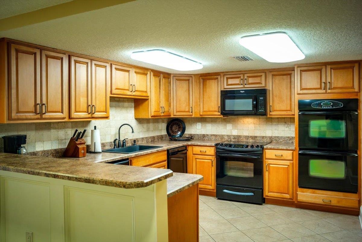 2 Dondanville Road, Unit 115 St. Augustine, FL 32080 - Photo 23 of 36 a kitchen with stainless steel appliances granite countertop a stove a sink and a microwave