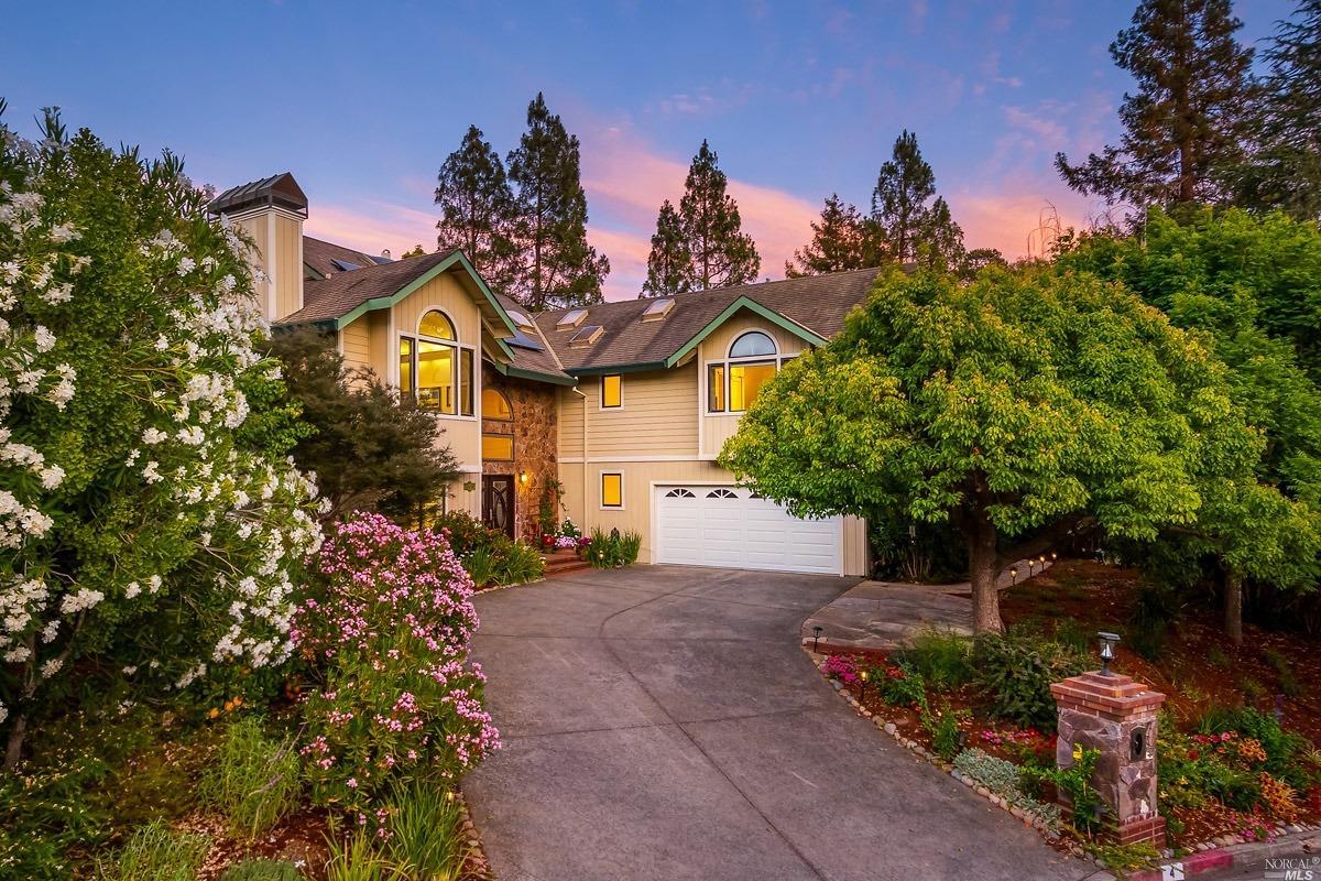 a front view of a house with a yard and fountain in middle