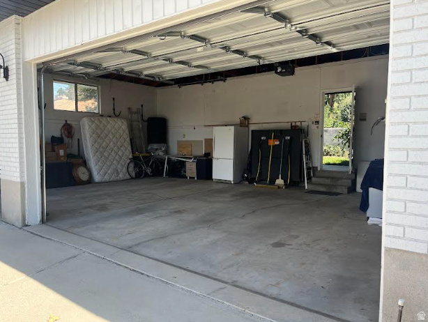 2329 Sublette Place Sandy, UT 84093 - Photo 56 of 56 Attached garage featuring a concrete floor, an overhead door, and a side access door