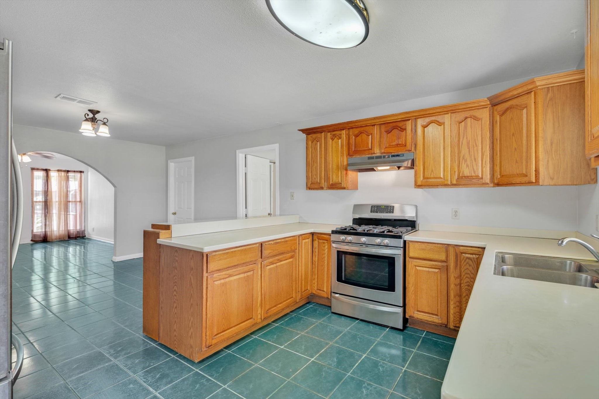 406 Red Ripple Road Houston, TX 77091 - Photo 12 of 37 a kitchen with stainless steel appliances granite countertop a stove a sink and a refrigerator