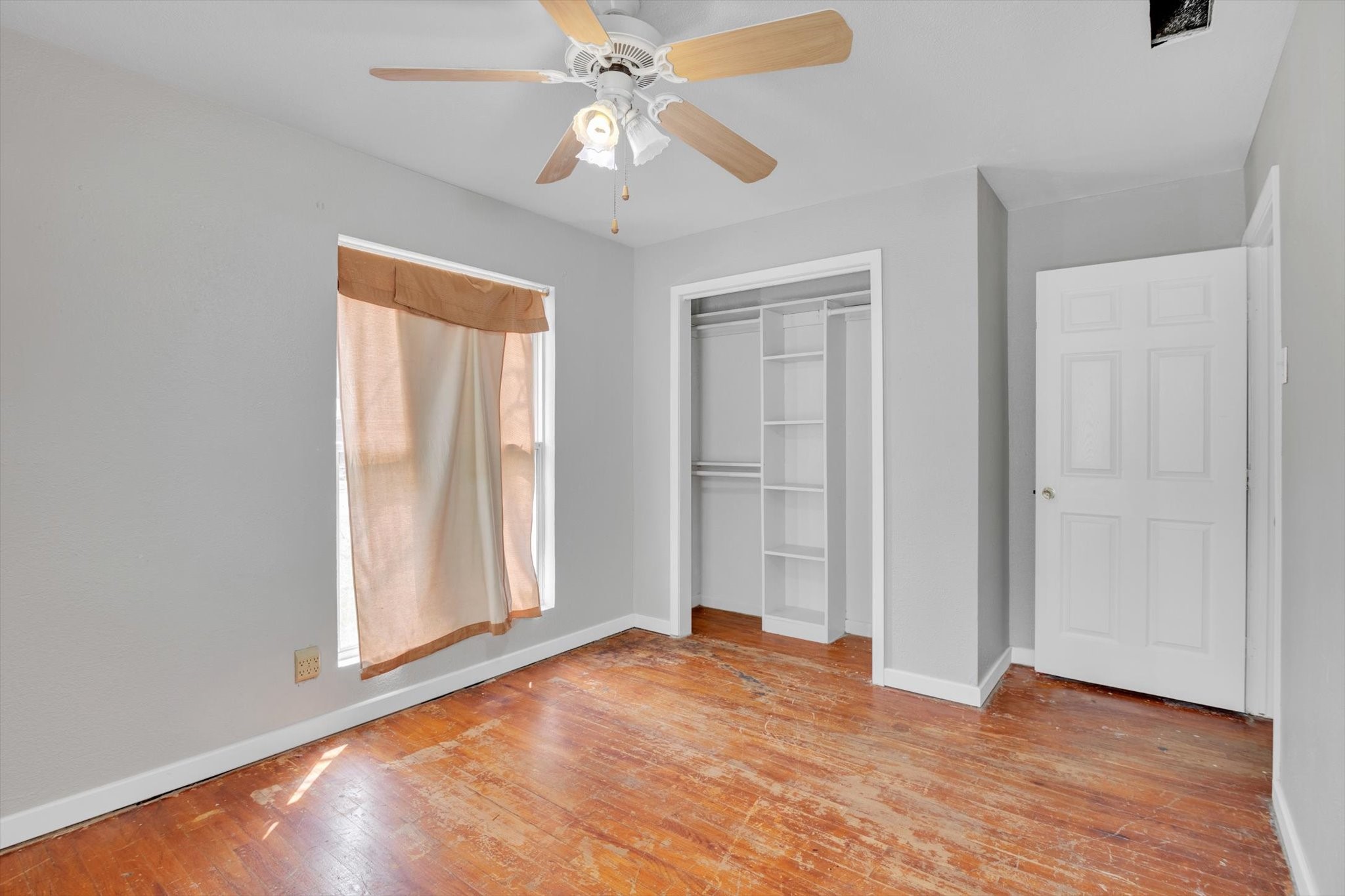406 Red Ripple Road Houston, TX 77091 - Photo 19 of 37 an empty room with wooden floor fan and windows