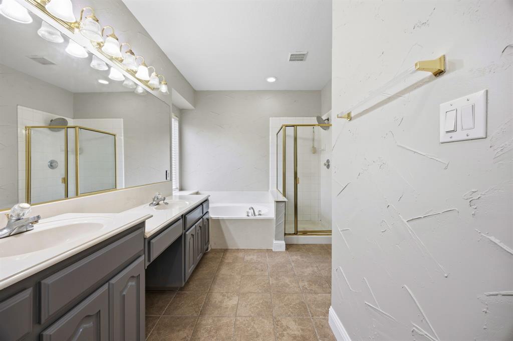1904 Meera Lane Mansfield, TX 76063 - Photo 23 of 35 a spacious bathroom with a double vanity sink toilet mirror and bathtub