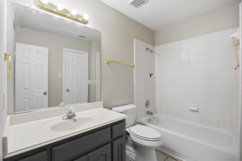 1904 Meera Lane Mansfield, TX 76063 - Photo 30 of 35 a bathroom with a sink a toilet a mirror a vanity and shower