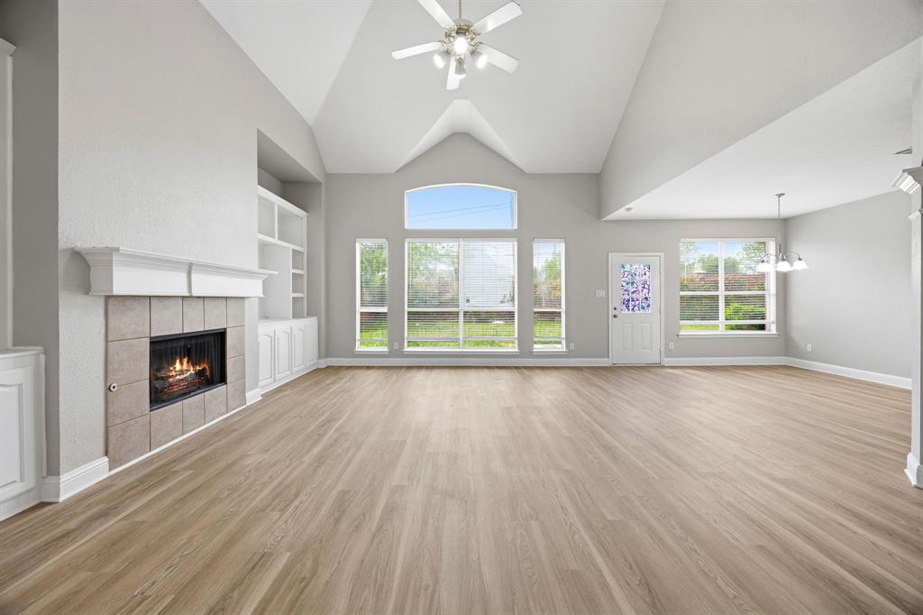 1904 Meera Lane Mansfield, TX 76063 - Photo 9 of 35 a view of an empty room with wooden floor fireplace and a window