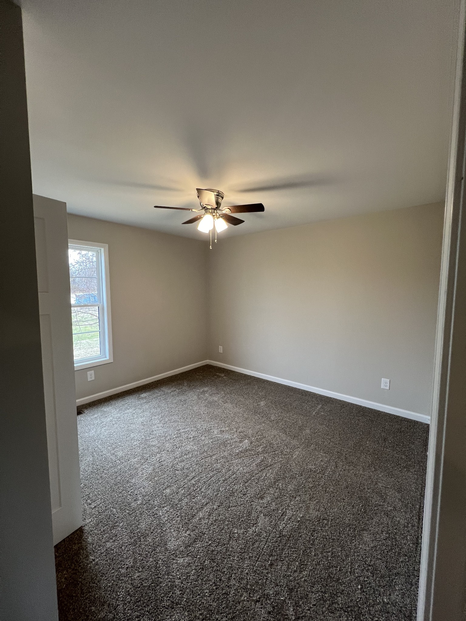 1669 New Deal Potts Road Portland, TN 37148 - Photo 15 of 17 an empty room with windows and chandelier fan