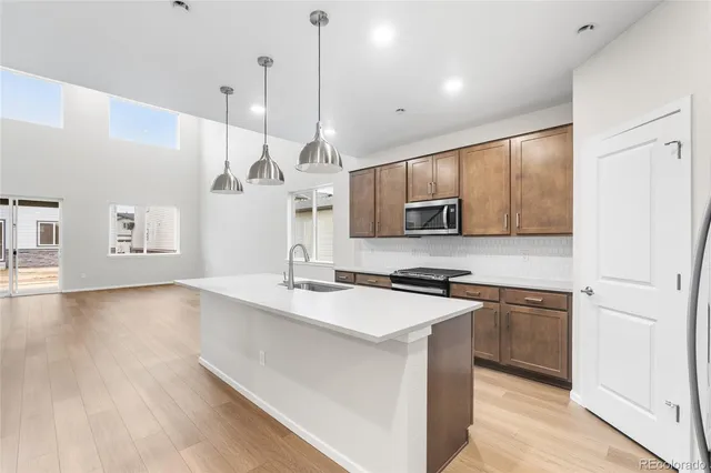 a kitchen with stainless steel appliances granite countertop a sink a stove and a refrigerator