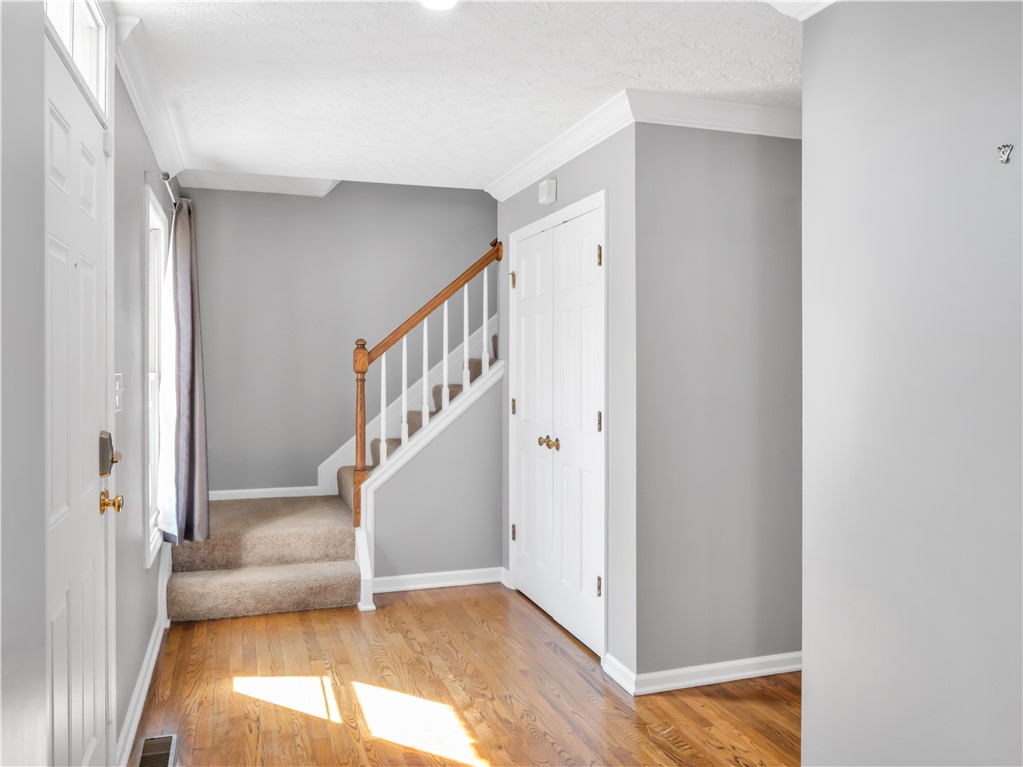 25 Callaway Springboro, OH 45066 - Photo 4 of 51 This inviting entryway features hardwood floors, a carpeted staircase, and crown molding.