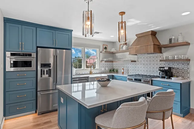 a kitchen with stainless steel appliances a sink stove and refrigerator