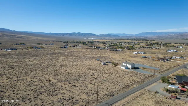 a view of a dry yard with wooden fence