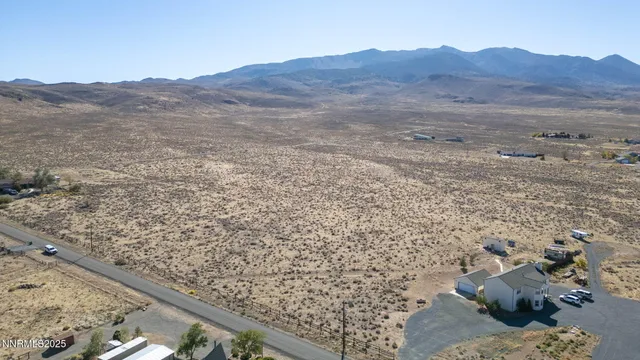 a view of a dry field with mountains in the background