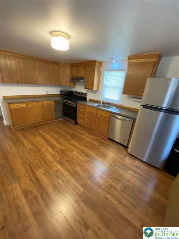 16 South 3rd Street, Unit 1 Emmaus, PA 18049 - Photo 9 of 12 a large kitchen with wooden floors and stainless steel appliances