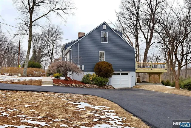 a view of a house with backyard and trees
