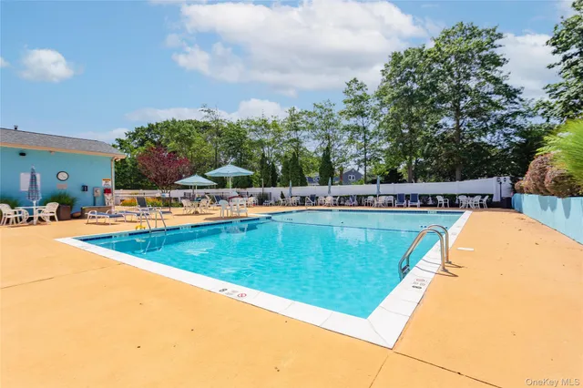 a view of a swimming pool with a bench and trees around