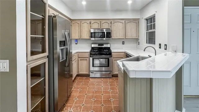 a kitchen with granite countertop a sink and stainless steel appliances