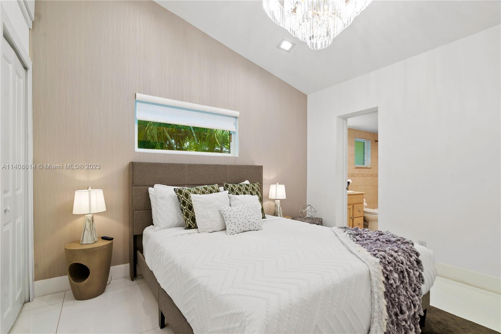 401 Southwest 23rd Road Miami, FL 33129 - Photo 22 of 43 a bedroom with a bed and a chandelier
