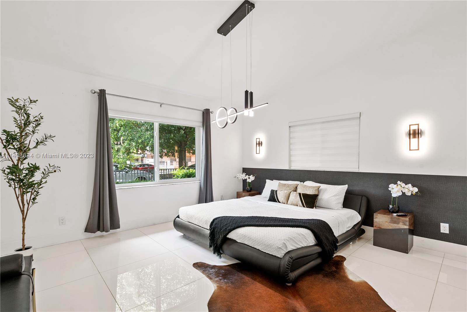 401 Southwest 23rd Road Miami, FL 33129 - Photo 7 of 43 a bedroom with a large bed and a potted plant