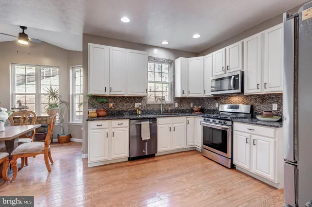 a kitchen with stainless steel appliances granite countertop a refrigerator and a stove