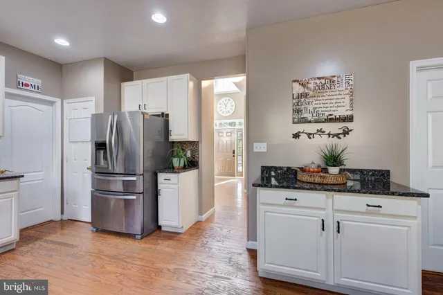 a kitchen with stainless steel appliances granite countertop a lot of counter space and wooden floors