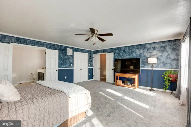 a view of a bedroom with wooden floor and windows
