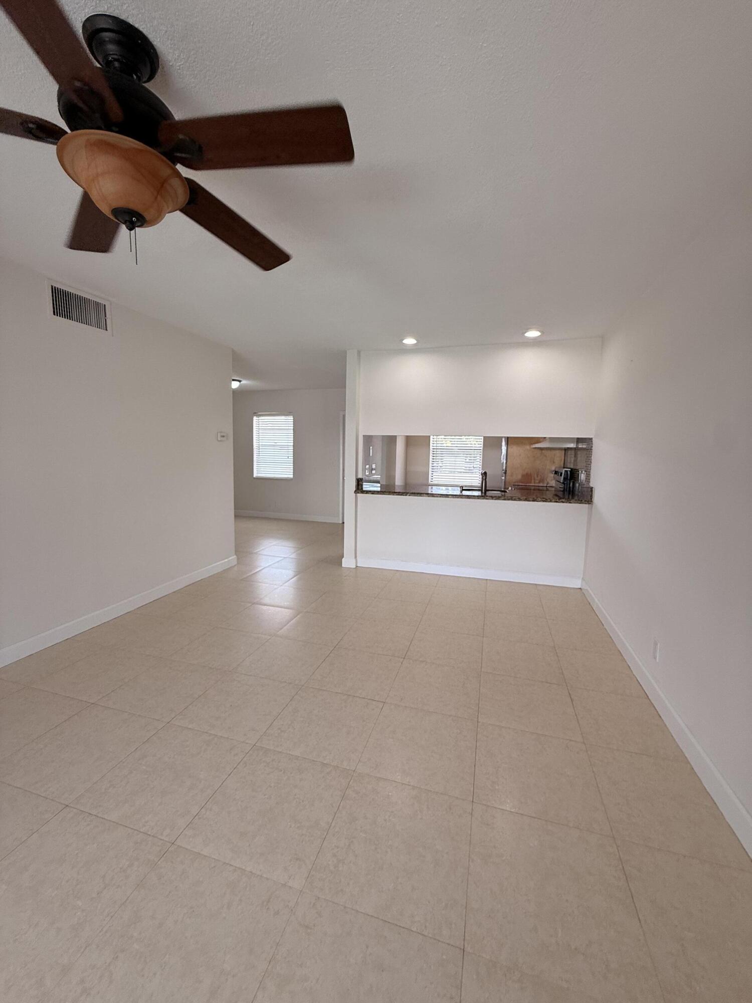 875 Northwest 13th Street, Unit 405 Boca Raton, FL 33486 - Photo 5 of 16 a view of a hallway with a kitchen
