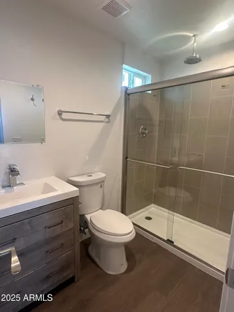 a bathroom with a sink a toilet and shower