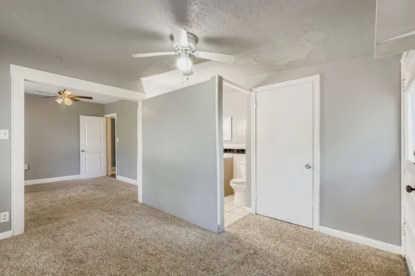 an empty room with closet and a chandelier fan