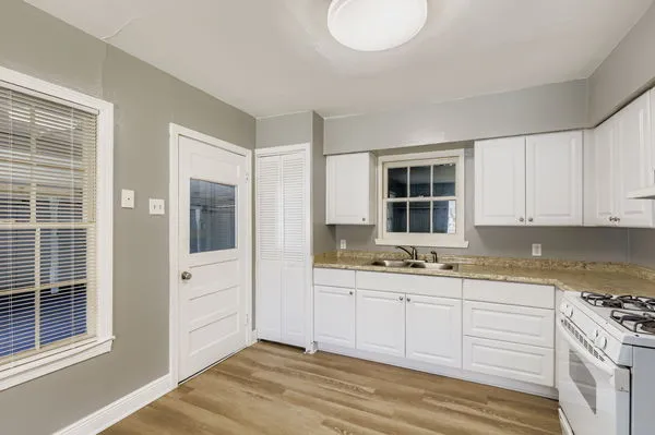 a kitchen with stainless steel appliances granite countertop a sink and cabinets with wooden floor