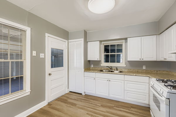 700 West St Johns Avenue Austin, TX 78752 - Photo 6 of 16 a kitchen with stainless steel appliances granite countertop a sink and cabinets with wooden floor