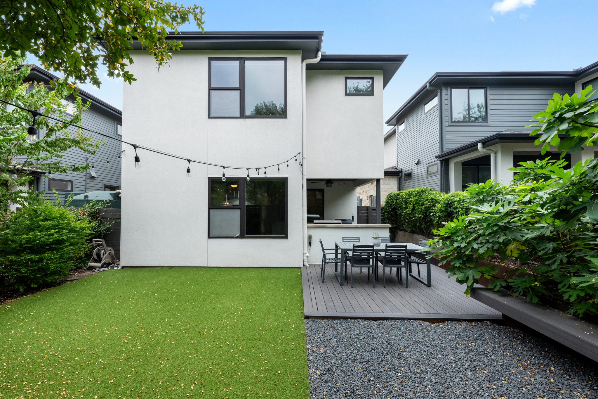 a view of a patio with table and chairs potted plants and large tree
