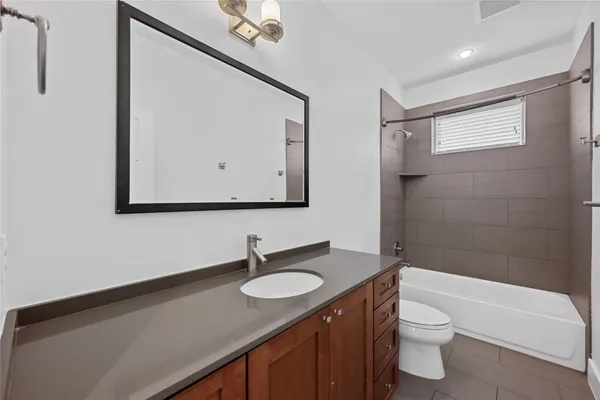 a bathroom with a granite countertop sink toilet and mirror